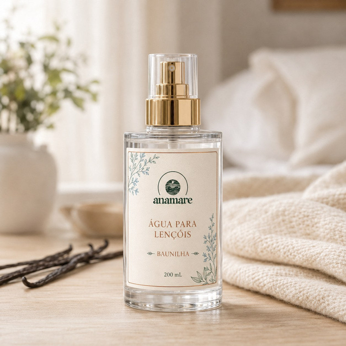 Água de Lençóis Anamare Baunilha, frasco de vidro de 200 mL com válvula spray dourada e rótulo cru, em quarto em tons de creme