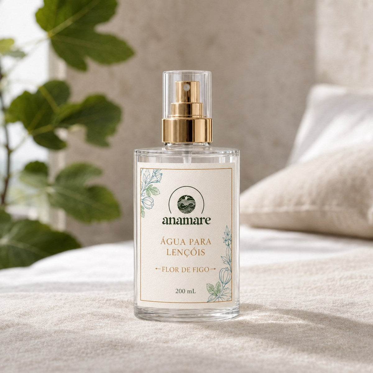 Água de Lençóis Anamare Flor de Figo, frasco de vidro de 200 mL com válvula spray dourada e rótulo cru, em parede de pedra com folha de figueira