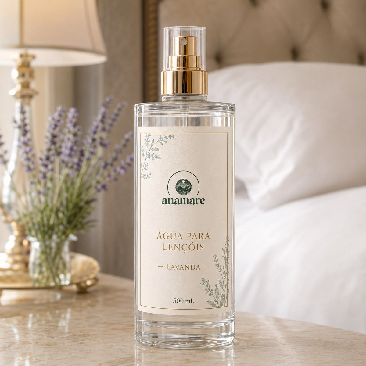 Água de Lençóis Anamare Lavanda, frasco de vidro de 500 mL com válvula spray dourada e rótulo cru, em quarto de linho claro com lavandas em vaso de cerâmica