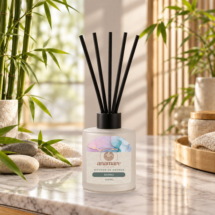 Difusor de Aromas Bambu 100 mL, frasco de vidro fosco com varetas pretas, em bancada de mármore com hastes de bambu e pedras