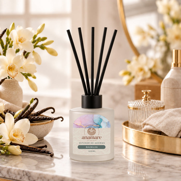 Difusor de Aromas Baunilha 100 mL, frasco de vidro fosco com varetas pretas, em bancada de mármore com favas de baunilha e orquídeas