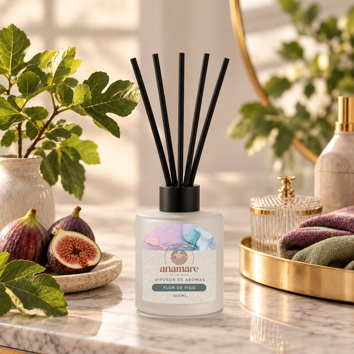 Difusor de Aromas Flor de Figo 100 mL, frasco de vidro fosco com varetas pretas, em bancada de mármore com figos e folhas de figueira