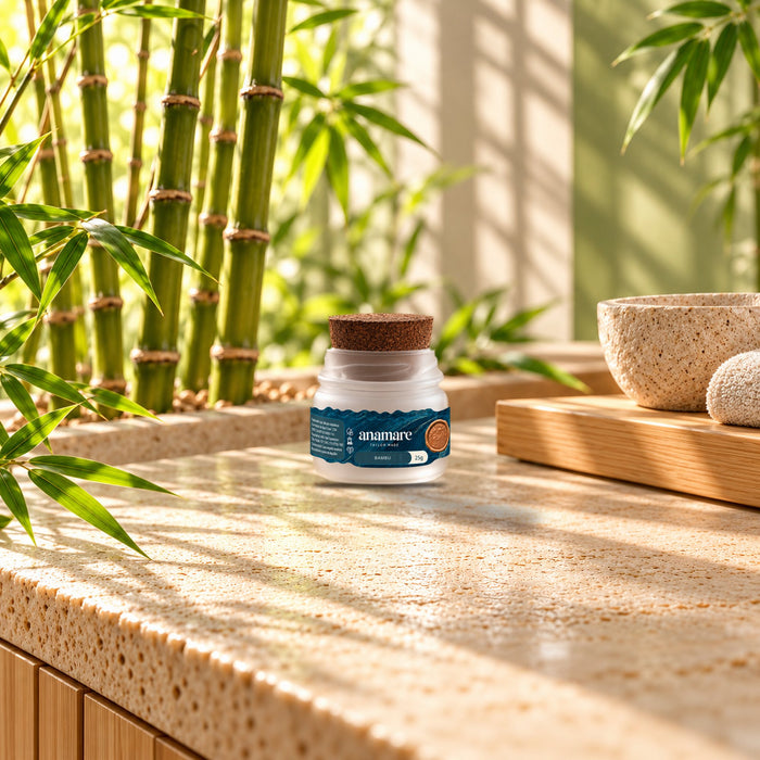 Vela aromática Petit 25 g Bambu sobre bancada de pedra, com hastes de bambu e uma tigela de pedra