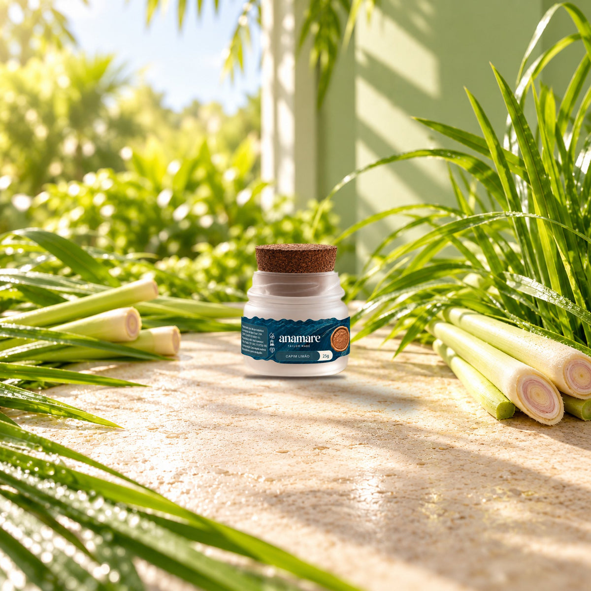 Vela aromática Petit 25 g Capim Limão sobre bancada de pedra, entre talos e folhas de capim-limão