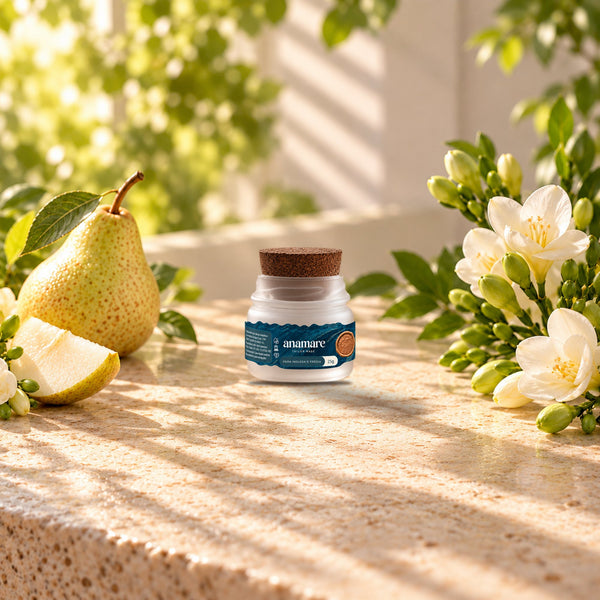 Vela aromática Petit 25 g Pera Inglesa e Frésia sobre bancada de pedra, entre peras e flores de frésia