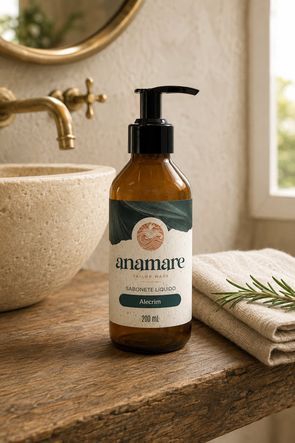 Sabonete Líquido para as Mãos Alecrim 200 mL, frasco âmbar com válvula pump preta, em bancada de banheiro com cuba de pedra e a fragrância representada ao lado