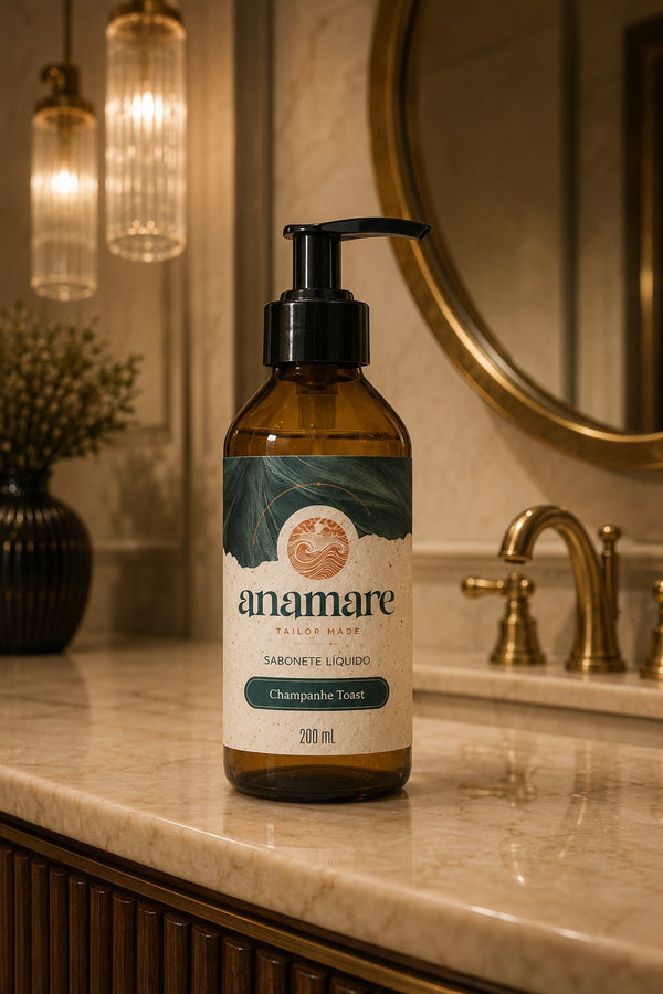 Sabonete Líquido para as Mãos Champanhe Toast 200 mL, frasco âmbar com válvula pump preta, em bancada de banheiro com cuba de pedra e a fragrância representada ao lado