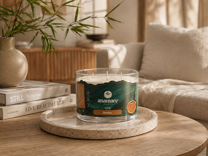 Vela Aromática Bambu Signature 500 g com três pavios de madeira, pote de vidro grosso em mesa de centro com bandeja de travertino e ramo de bambu