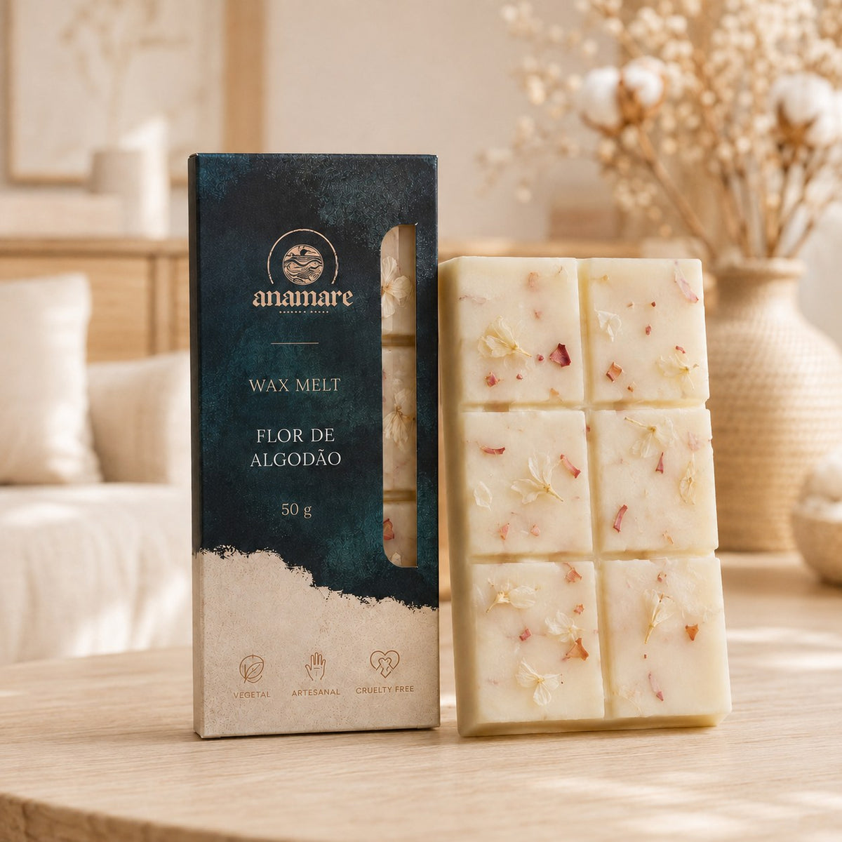 Wax Melt Anamare Flor de Algodão de 50 g, barra de cera vegetal com pétalas secas ao lado da caixa azul-petróleo com janela, em sala clara com sofá de linho, almofadas brancas e ramos de algodão secos em vaso de palha